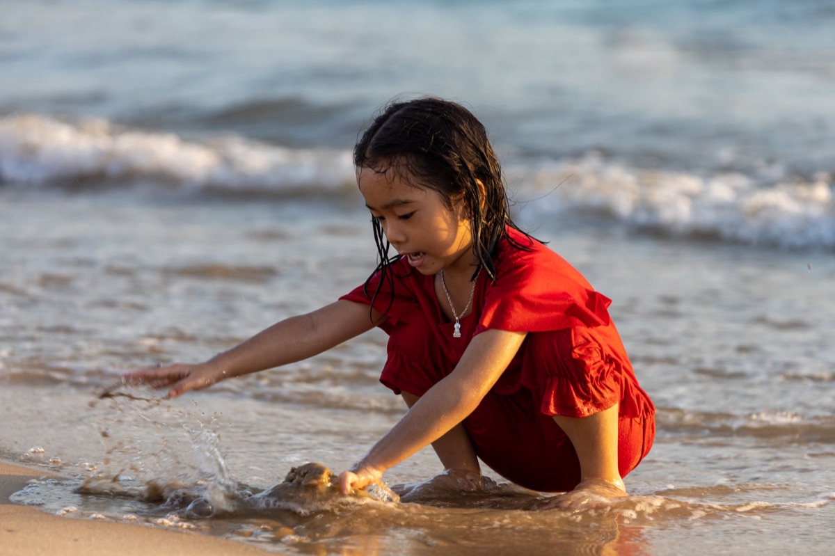 niño jugando en playa