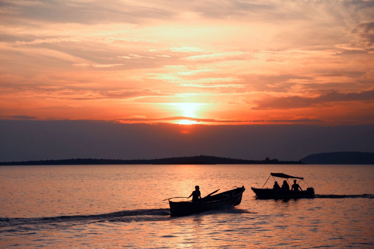 Sunrise over ocean with fishing boat