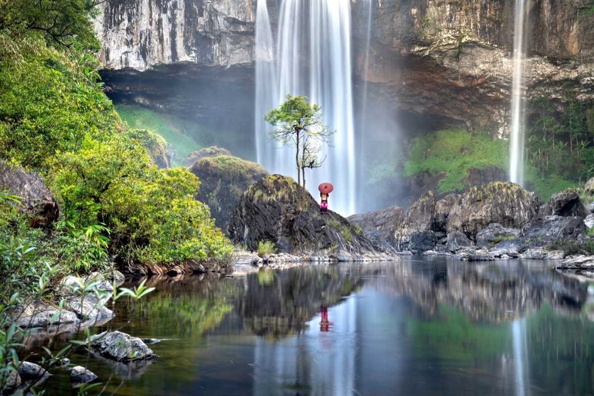 family in front of tropical waterfall