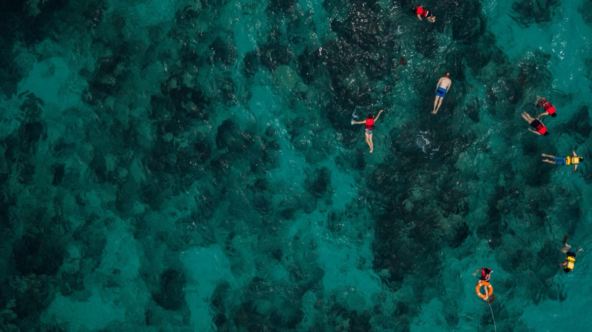 Family snorkeling with gear and coral reef