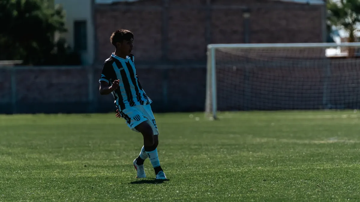 Young male soccer player mid-action on an outdoor field during a match.