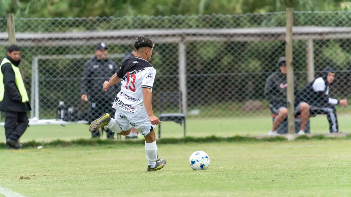Young soccer player in dynamic action during a match on a grassy field.