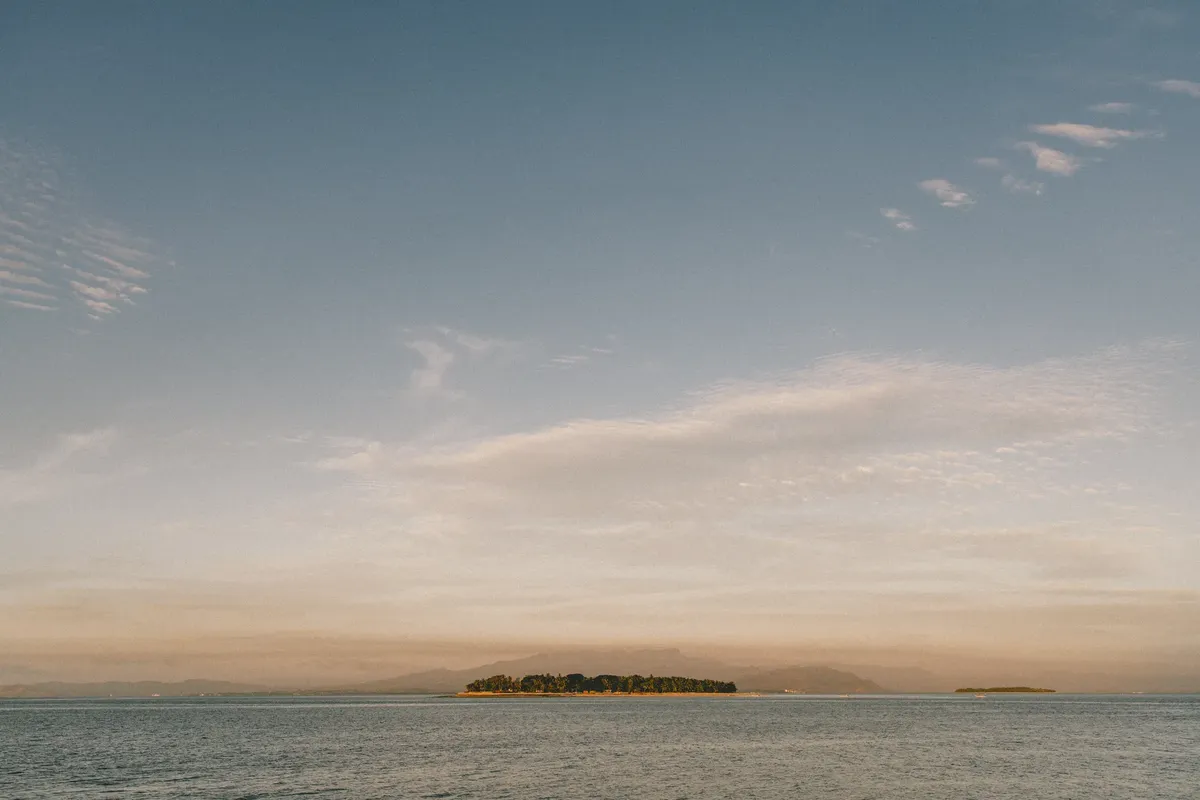 Beautiful view of a serene island and ocean under a glowing sunrise in Fiji.
