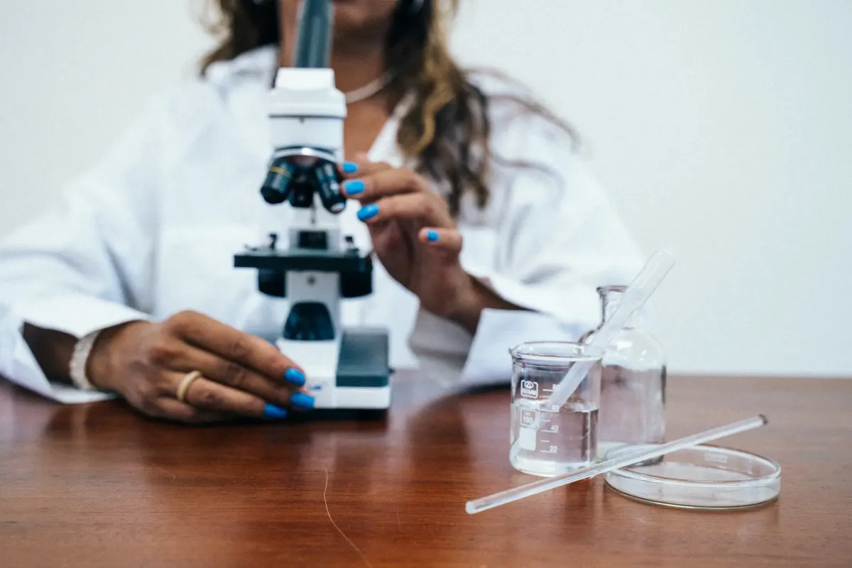 A female scientist conducting research with a microscope and laboratory equipment.